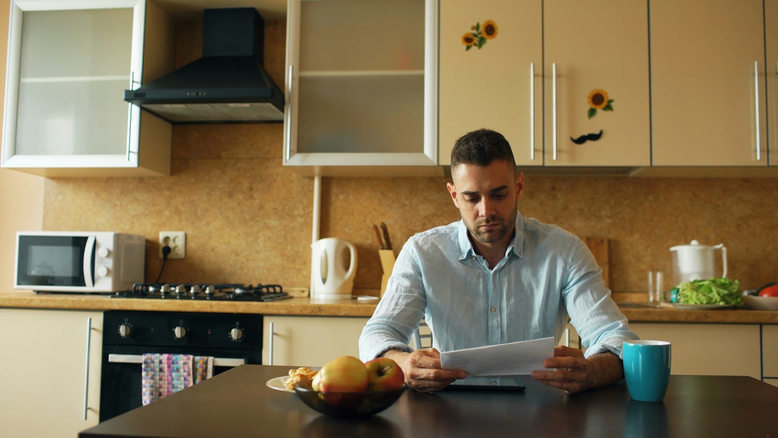 Hombre revisando documentos en la mesa de la cocina